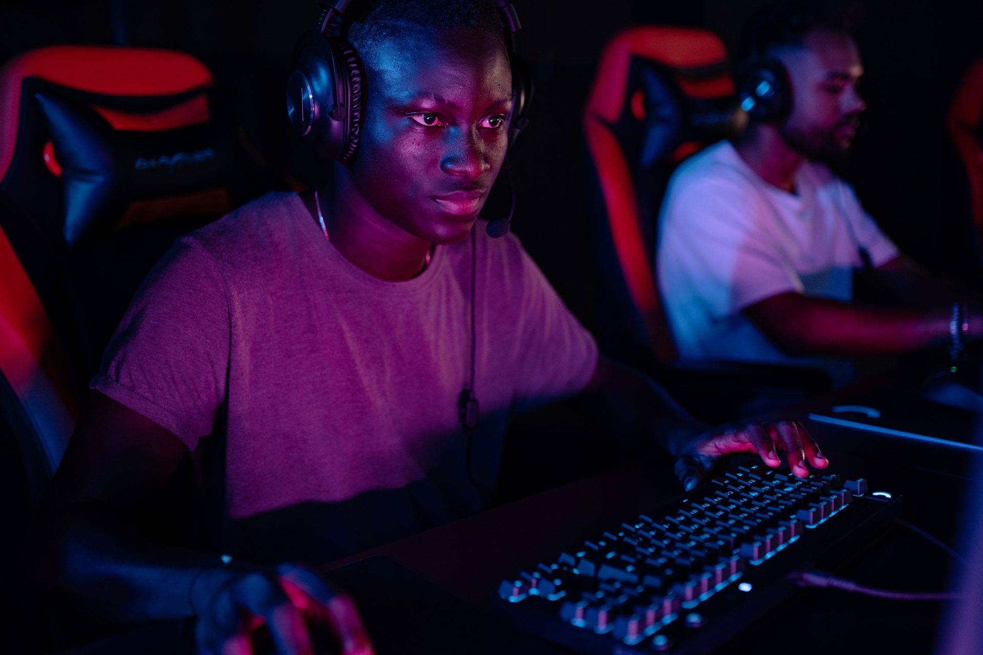 Cluster of gaming stations with bright screens around a shared desk late at night